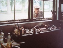 Jan Broeze kijkt door raam atelier